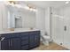 Bathroom featuring double sinks, white quartz countertop, navy cabinets, and glass-enclosed shower at 7274 Deer Valley Cir, Tampa, FL 33635