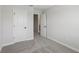 Neutral bedroom featuring gray carpet, light gray walls, white trim, and two doors at 7274 Deer Valley Cir, Tampa, FL 33635