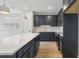 Modern kitchen with navy cabinets, a white countertop island, stainless appliances, and tile flooring at 7274 Deer Valley Cir, Tampa, FL 33635