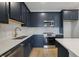 Beautiful kitchen with navy cabinets, chevron backsplash, stainless appliances, and quartz countertop at 7274 Deer Valley Cir, Tampa, FL 33635