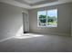 Unfinished bedroom featuring a bright window, tray ceiling, and neutral paint, awaiting personalization and finishing touches at 7284 Deer Valley Cir, Tampa, FL 33635