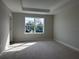 Empty bedroom with a large window and light gray carpet at 7284 Deer Valley Cir, Tampa, FL 33635
