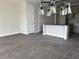 Open concept living room and kitchen featuring gray wood-look tile and a modern light fixture at 7284 Deer Valley Cir, Tampa, FL 33635