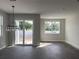 Living room featuring gray wood-look tile floors, a window, and sliding glass door access to the backyard at 7284 Deer Valley Cir, Tampa, FL 33635