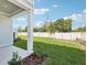 View of the backyard and patio, featuring lush green grass and a white fence at 7294 Deer Valley Cir, Tampa, FL 33635