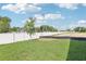 A beautiful backyard with a new fence and green grass with a small tree planted nearby at 7294 Deer Valley Cir, Tampa, FL 33635
