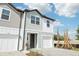 Charming two-story townhome featuring a one car garage, blue siding, and tropical landscaping at 7294 Deer Valley Cir, Tampa, FL 33635