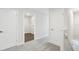 A well-lit hallway with carpet and doors leading to other rooms, with closet inside one of the rooms at 7294 Deer Valley Cir, Tampa, FL 33635
