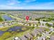 Panoramic aerial view shows a home with mature trees and landscaping with lake view from desirable neighborhood at 10607 Standing Stone Drive, Wimauma, FL 33598