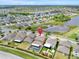 An aerial view displays a home in a beautiful community featuring a private pool and a scenic view of a nearby lake at 10607 Standing Stone Drive, Wimauma, FL 33598