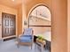 Inviting covered entrance with a cozy chair and view of the home's address on the garage at 10607 Standing Stone Drive, Wimauma, FL 33598