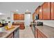 Well-equipped kitchen featuring dark cabinetry, granite countertops, and stainless steel appliances at 10607 Standing Stone Drive, Wimauma, FL 33598