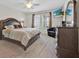 Cozy main bedroom with a large bed, dresser, and TV for relaxation at 10607 Standing Stone Drive, Wimauma, FL 33598