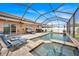 Tranquil pool and spa area with covered patio seating and lush landscaping at 10607 Standing Stone Drive, Wimauma, FL 33598