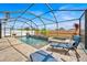 Relaxing screened-in pool and spa with stone waterfall and lounge chair at 10607 Standing Stone Drive, Wimauma, FL 33598