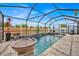 Inviting screened-in pool with serene stone waterfall and lush greenery at 10607 Standing Stone Drive, Wimauma, FL 33598