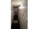 Hallway with neutral walls, lighting fixture and black carpet, leading to various rooms within the home at 12485 Land St, Largo, FL 33773