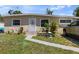Modest single-story home with small front yard, walkway, and beige exterior paint at 215 Melody Ln, Largo, FL 33771
