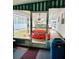 A red car parked in an enclosed car port with a lawn visible outside of the structure at 9790 66Th N St # 238, Pinellas Park, FL 33782