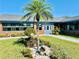 Beautifully landscaped front yard with vibrant flowers, a small palm tree, and an inviting entrance to the building at 9790 66Th N St # 238, Pinellas Park, FL 33782