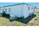 Exterior angle of the home showcasing the home's white siding, blue trim, and well-maintained lawn at 9790 66Th N St # 238, Pinellas Park, FL 33782