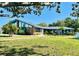 Charming single-story home with a well-manicured lawn, mature trees, and a unique architectural design featuring large windows at 9790 66Th N St # 238, Pinellas Park, FL 33782