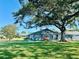 Inviting blue home with a large tree providing shade, surrounded by a green lawn and well-kept landscaping at 9790 66Th N St # 238, Pinellas Park, FL 33782