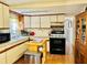 Well-lit kitchen with white cabinets, modern appliances, and a view into the dining area at 9790 66Th N St # 238, Pinellas Park, FL 33782
