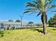 Community pool with lush greenery, palm trees, and a view of the building exterior in a serene setting at 9790 66Th N St # 238, Pinellas Park, FL 33782