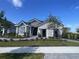 Charming single-story home featuring stone accents, gray siding, manicured landscaping, and a welcoming entrance at 2718 Wise River Lane, Zephyrhills, FL 33539