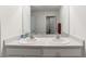 Bright bathroom featuring a double sink vanity with white cabinets and a large mirror at 3715 Capri Coast, Plant City, FL 33565