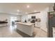 Open kitchen with island, stainless appliances, and tiled floor leading to a dining area at 3715 Capri Coast, Plant City, FL 33565