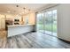 Bright open floor plan kitchen and dining area with stainless steel appliances, white cabinetry and wood grain floors at 80 Sequoyah Dr, Port Charlotte, FL 33954