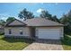 Charming single-story home featuring a neutral color palette, attached two car garage, and patterned paver driveway at 80 Sequoyah Dr, Port Charlotte, FL 33954