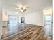 Spacious living room featuring wood grain floors, ceiling fan, neutral paint, and a sliding glass door at 80 Sequoyah Dr, Port Charlotte, FL 33954