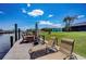 Lounge on the dock chairs with waterfront views, under blue skies, in this beautiful backyard at 5202 Forbes Ter, Port Charlotte, FL 33981
