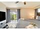 This main bedroom has a sliding glass door to the outside, a ceiling fan, TV, and a bed at 5202 Forbes Ter, Port Charlotte, FL 33981
