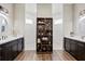 Luxurious bathroom with dual vanities, separate shower rooms, and a stylish decorative cabinet at 6306 Foxbrook Trl, Parrish, FL 34219