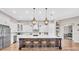 Bright kitchen with white cabinets, stainless appliances, large island with seating, and wood floors at 6306 Foxbrook Trl, Parrish, FL 34219