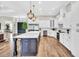 Open concept kitchen with white cabinets, stainless steel appliances, large island, and hardwood floors at 6306 Foxbrook Trl, Parrish, FL 34219