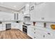Gourmet kitchen featuring custom white cabinets, stainless steel appliances, and wood flooring at 6306 Foxbrook Trl, Parrish, FL 34219