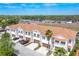 An aerial view featuring townhomes with brown roofs, well-kept lawns, and a nearby highway at 8614 Miramar Terrace Cir, Temple Terrace, FL 33637