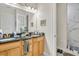 Bathroom featuring double sink vanity with granite countertops, a large mirror, and a walk-in shower at 8614 Miramar Terrace Cir, Temple Terrace, FL 33637