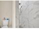 Modern bathroom featuring white marble-tiled shower, toilet, and neutral wall paint at 8614 Miramar Terrace Cir, Temple Terrace, FL 33637