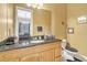 Bathroom features a wooden vanity with a dark countertop and a decorative mirror at 8614 Miramar Terrace Cir, Temple Terrace, FL 33637