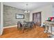 Inviting dining area with rustic accent wall, modern lighting, and an open layout perfect for entertaining guests at 8614 Miramar Terrace Cir, Temple Terrace, FL 33637