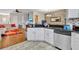 Spacious kitchen with granite countertops, white cabinetry, stainless steel appliances, and adjacent dining area at 8614 Miramar Terrace Cir, Temple Terrace, FL 33637