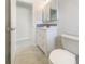 Cozy bathroom featuring a sink with a white cabinet, decorative mirror and blue accent tile at 111 Englewood Garden Ct, Englewood, FL 34223