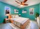 Vibrant bedroom featuring teal walls, modern furniture, and plenty of natural light at 111 Englewood Garden Ct, Englewood, FL 34223
