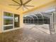 Covered brick patio with sliding glass door leads to screened in pool with outdoor fan at 111 Englewood Garden Ct, Englewood, FL 34223